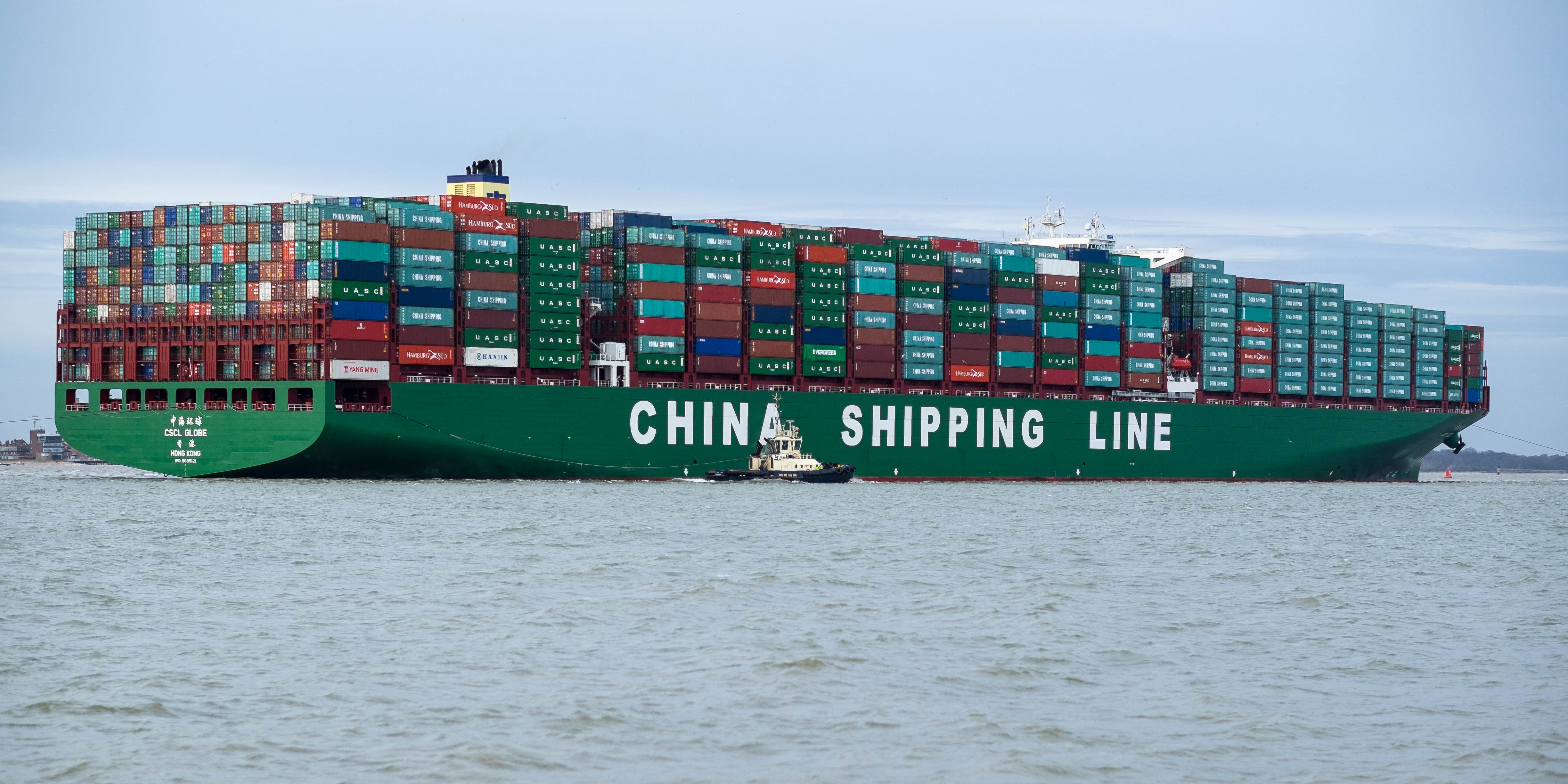 Large container ship carrying stacked freight containers at sea